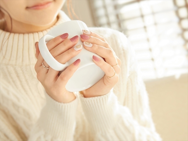あたたかい飲み物を手に持ちながらひと息つく女性のイメージ