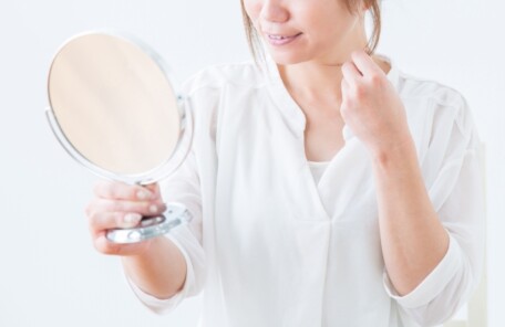 鏡を見ながら髪を気にする女性のイメージ