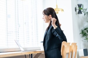 肩や首の緊張を感じながら過ごす女性のイメージ
