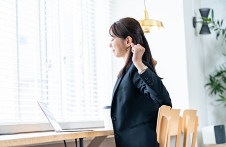 肩や首の緊張を感じながら過ごす女性のイメージ