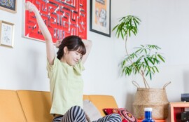 ソファで伸びをする女性。セルフケアはゆるゆると。続かなくても大丈夫です。