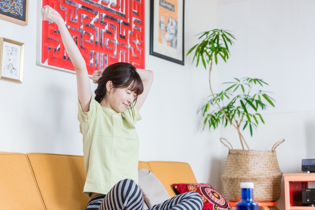 ソファで伸びをする女性。セルフケアはゆるゆると。続かなくても大丈夫です。